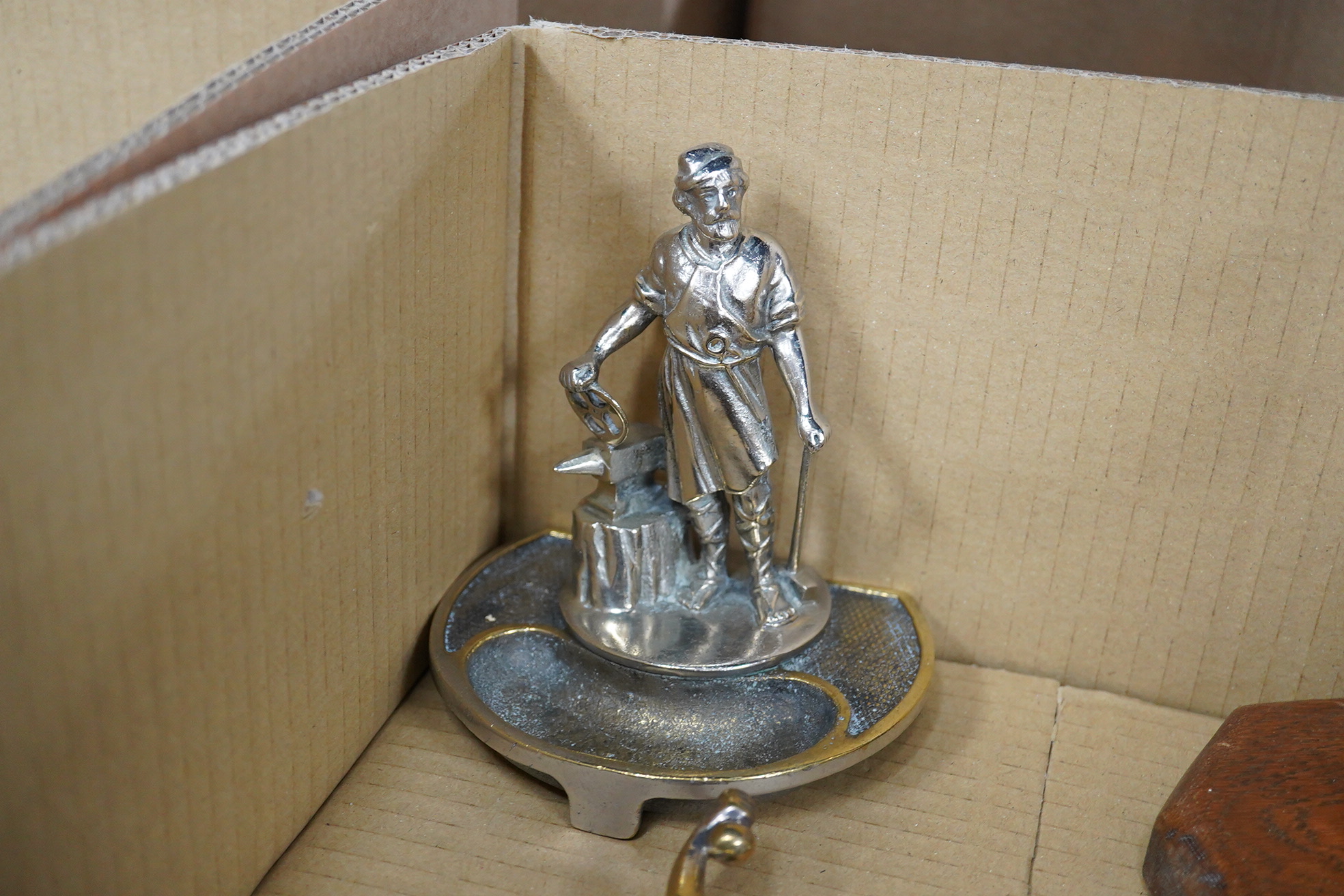 Five chrome and brass car mascots, including a knight, a policeman, a figure of Mercury, etc. together with two Art Deco table lighters as female figures, and an ashtray with the figure of a blacksmith (8)